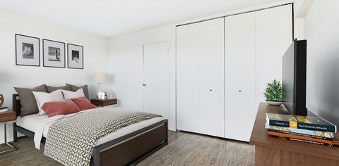 a bedroom with white walls and a bed with a red pillow at The Ivanhoe Apartments, Hackensack, 07601